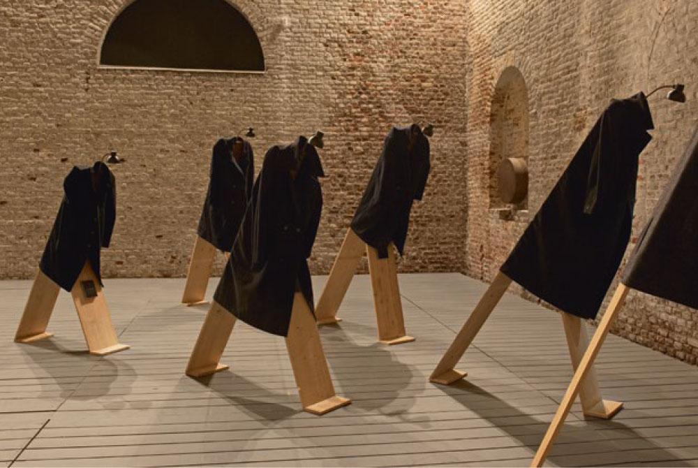 Speaking Up, 2005. Wooden figures, secondhand coats, lamps, motion detector, sound, dimensions variable Installation at MAC’s Grand-Hornu, Belgium, 2015