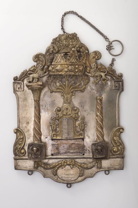 Torah shield with dedicatory inscription, decorated with menorah, lions and crown