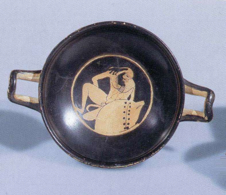 Attic red-figure <i>kylix</i> (wine cup) depicting a drunken Silenos besides a wineskin