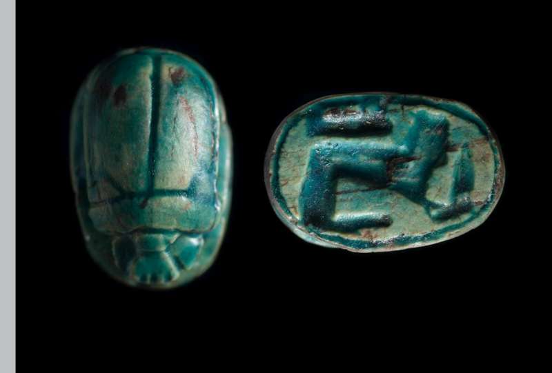 Scarab depicting a reclining sphinx with a reed or knife on its front paws
