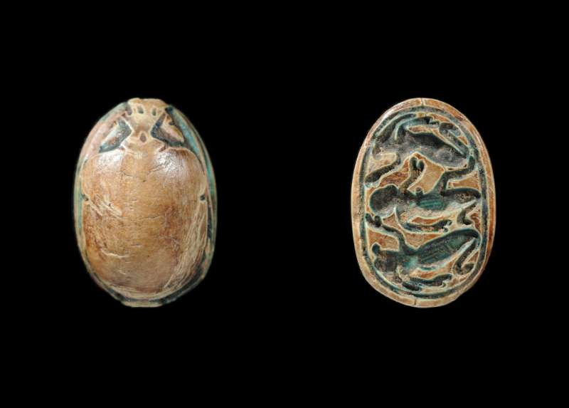 Canaanite scarab depicting a semi-kneeling figure flanked by kneeling falcon-headed figures raising their arms in adoration